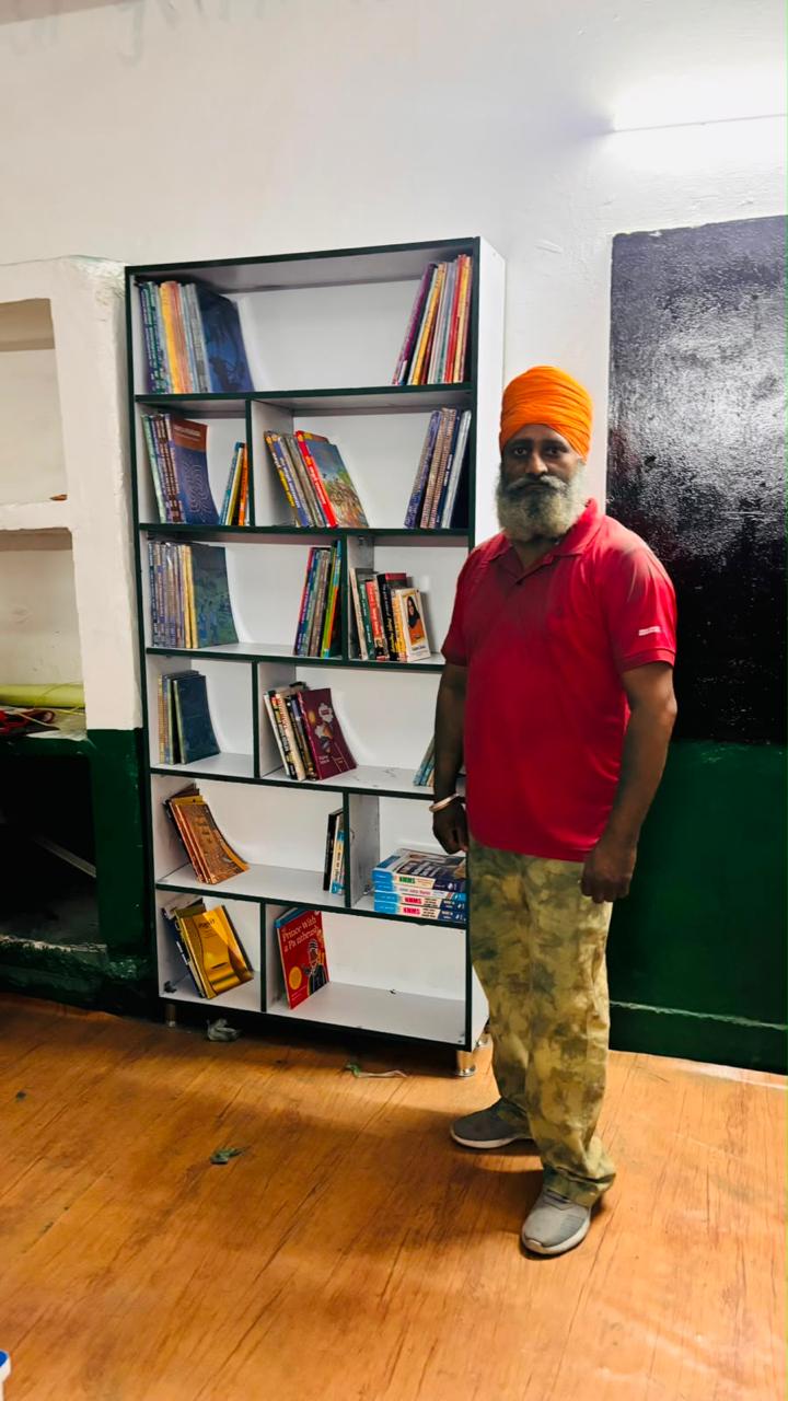 A Texla participant beside the newly stocked bookshelf