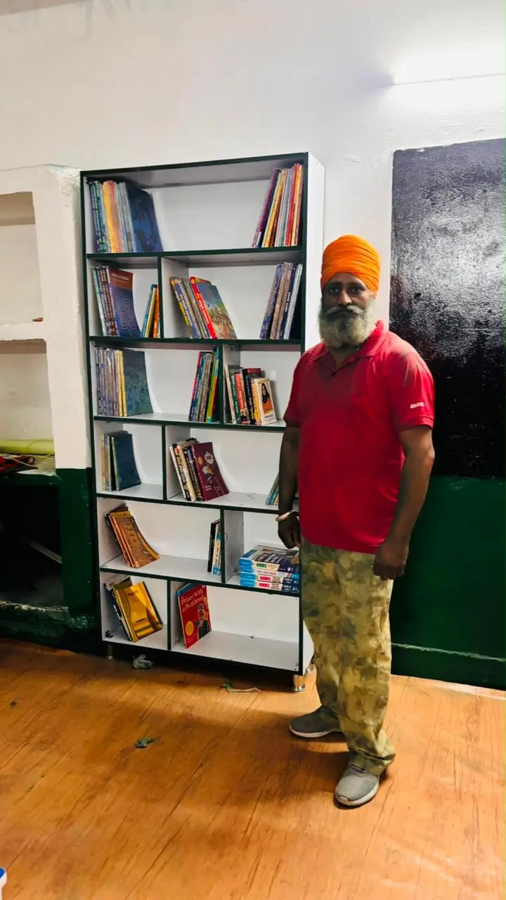 A Texla participant beside the newly stocked bookshelf